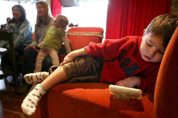 Matthew West, 3, watches a video on his Mom's iPhone while she talks with friends at Starbucks' Roy Street Coffee and Tea in Seattle, Washington, March 25, 2010.