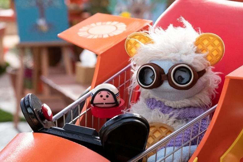 Waffles wearing goggles and Mochi wearing a helmet, sitting together in a go-kart