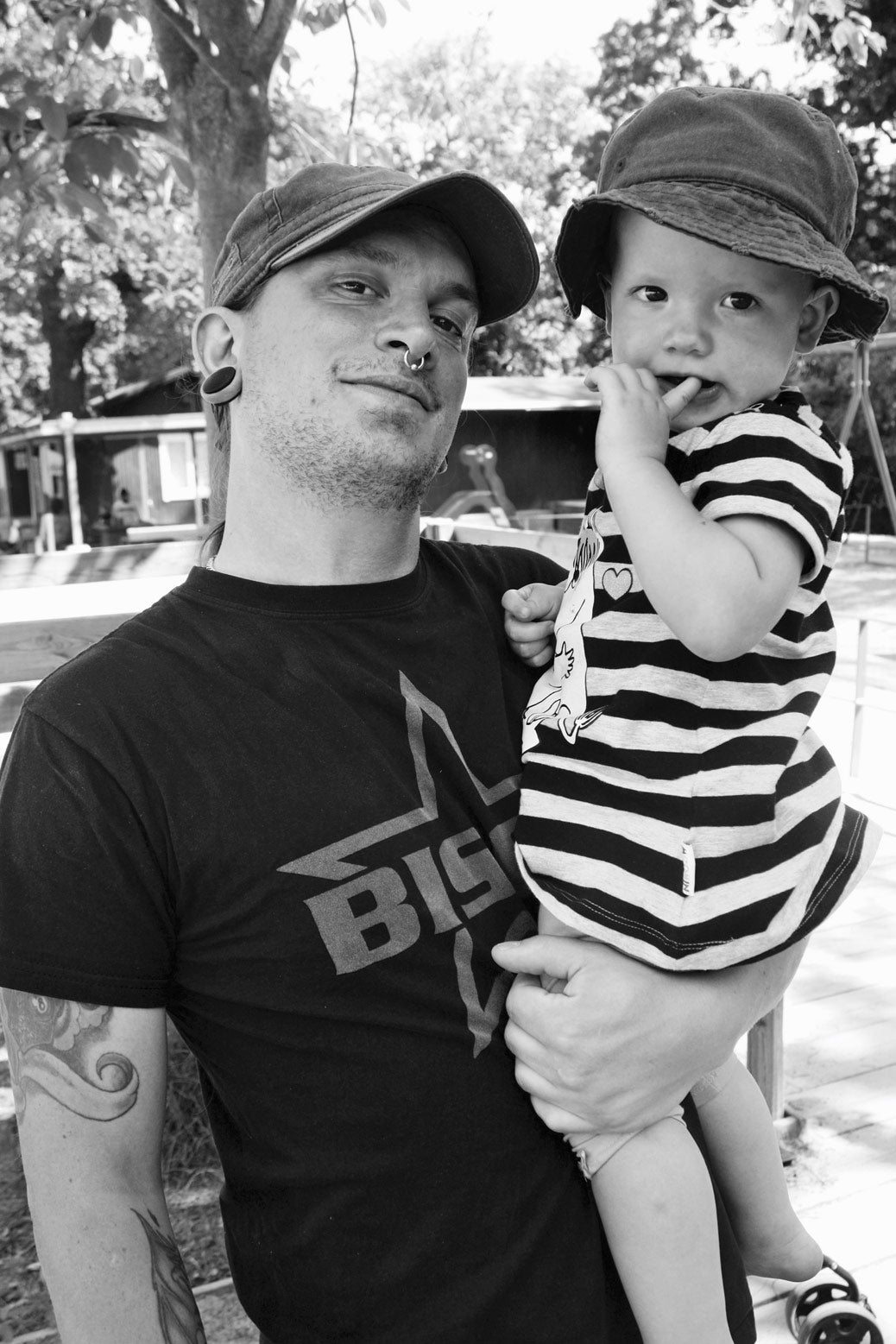 Here, a father and his toddler just finished playing on a swingset in a busy neighborhood park.