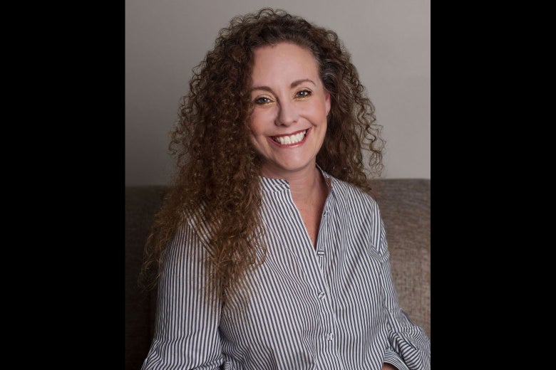 Swetnick, seated in a button-down shirt, smiles while looking into the camera.