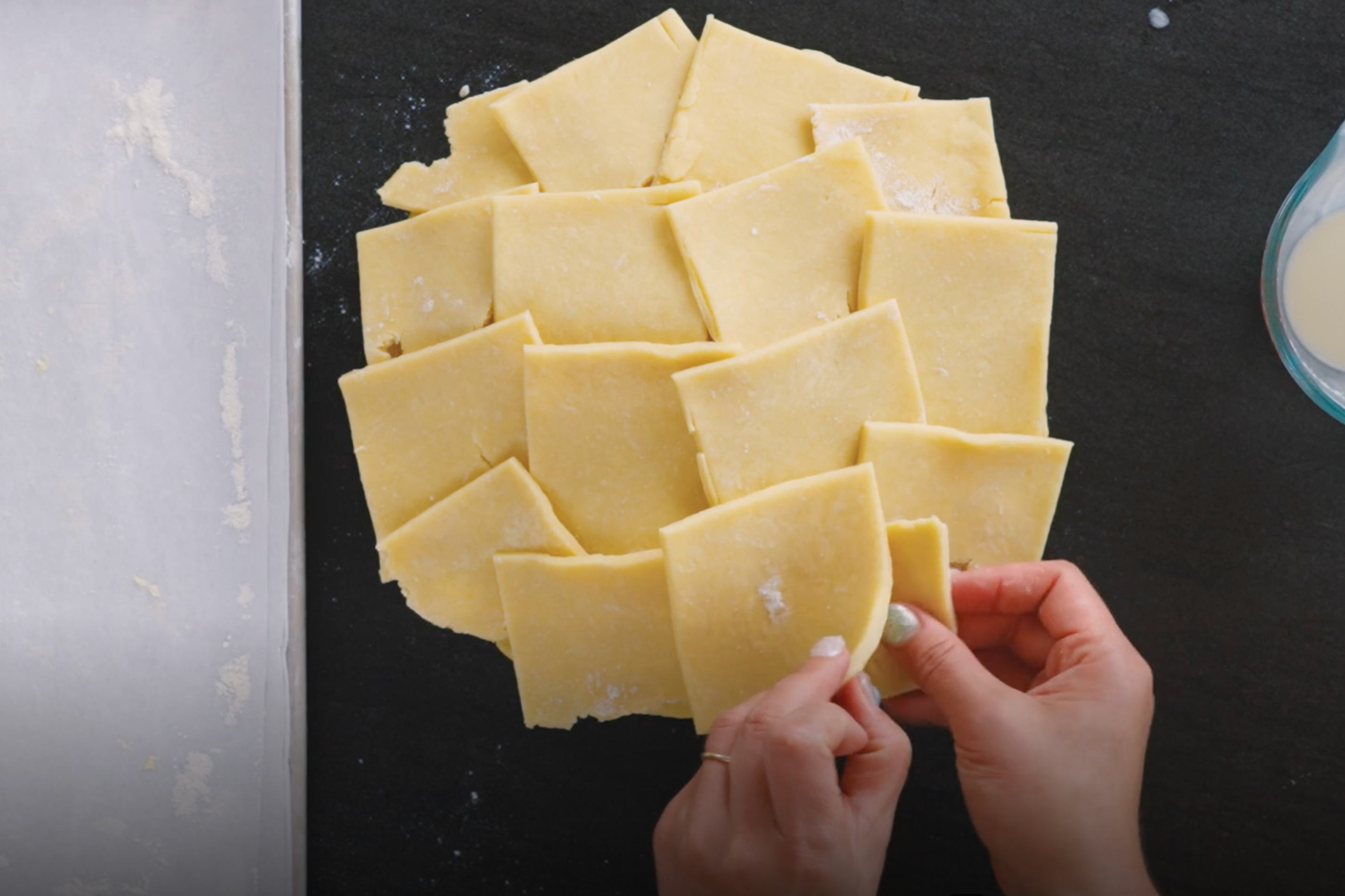 Pie dough singles being laid on top of filling.