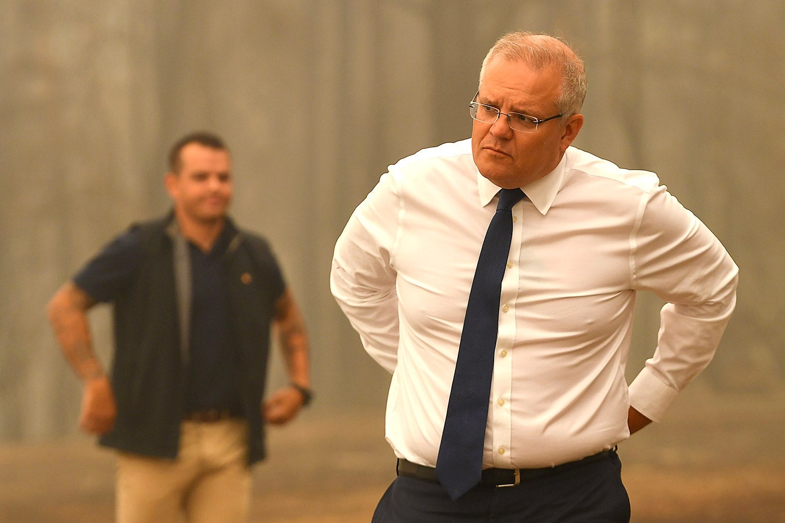 Scott Morrison, in shirt sleeves, with his hands behind his back.