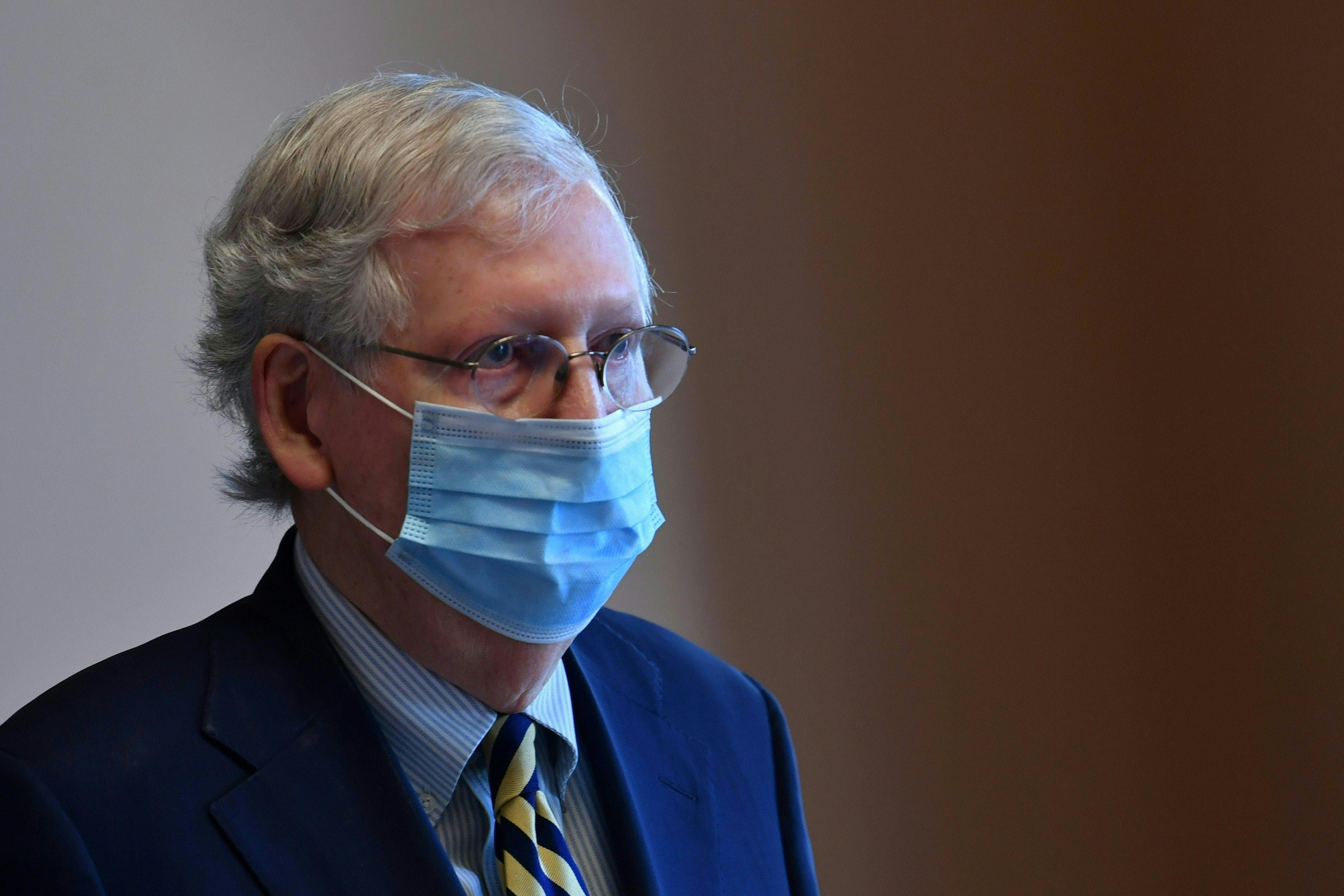 McConnell's eyes look pretty dead. He's wearing a blue mask and slightly darker blue suit.