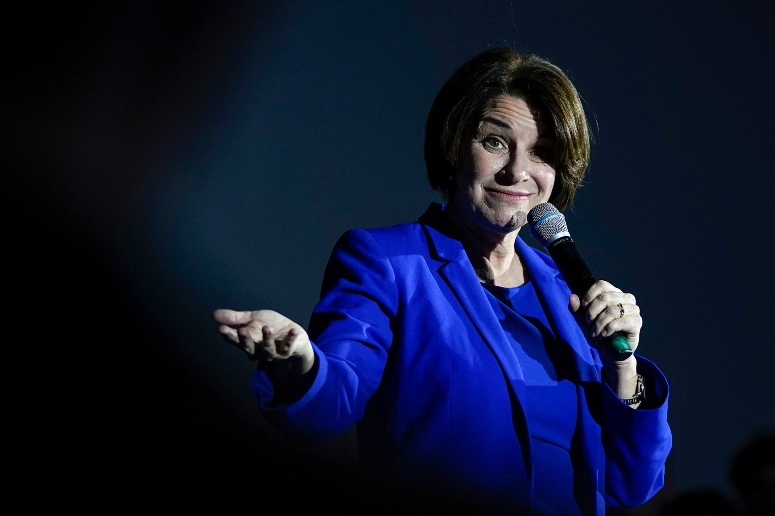 Amy Klobuchar speaks into the microphone in her left hand while gesturing with her right.