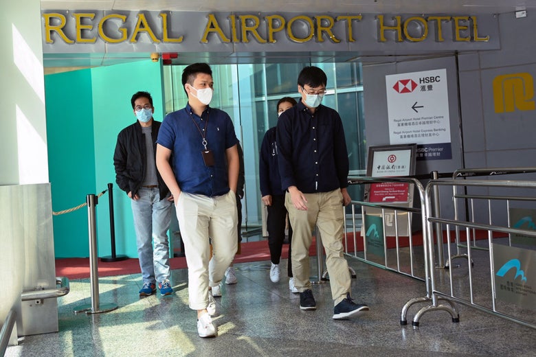People leave the Regal Airport Hotel at Chek Lap Kok airport in Hong Kong on November 26, 2021, where a new Covid-19 variant was detected in a traveler from South Africa and who has since passed it on to a local man whilst in quarantine. 
