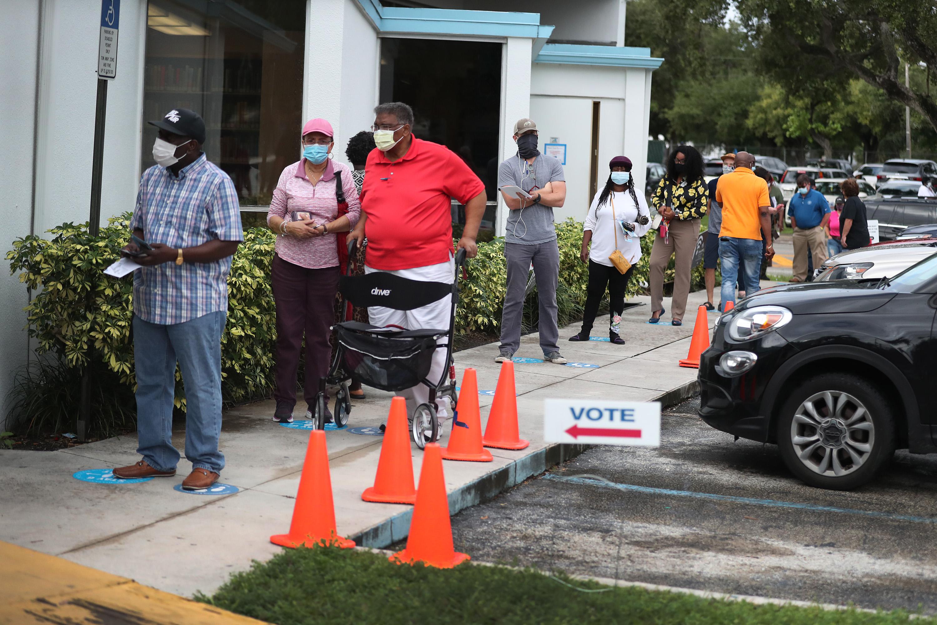 Voters wait in line to cast their early ballots in Miami.