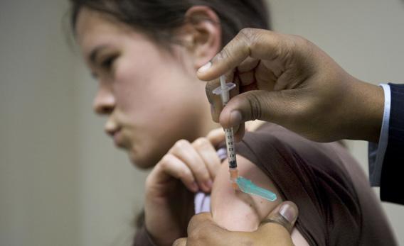 A young woman gets an H1N1 flu vaccine at Delaney Sisters Medical Center in 2009 in New York. 