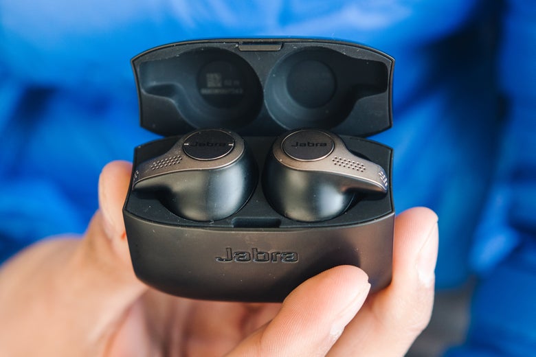 a hand holding Jabra Elite headphones