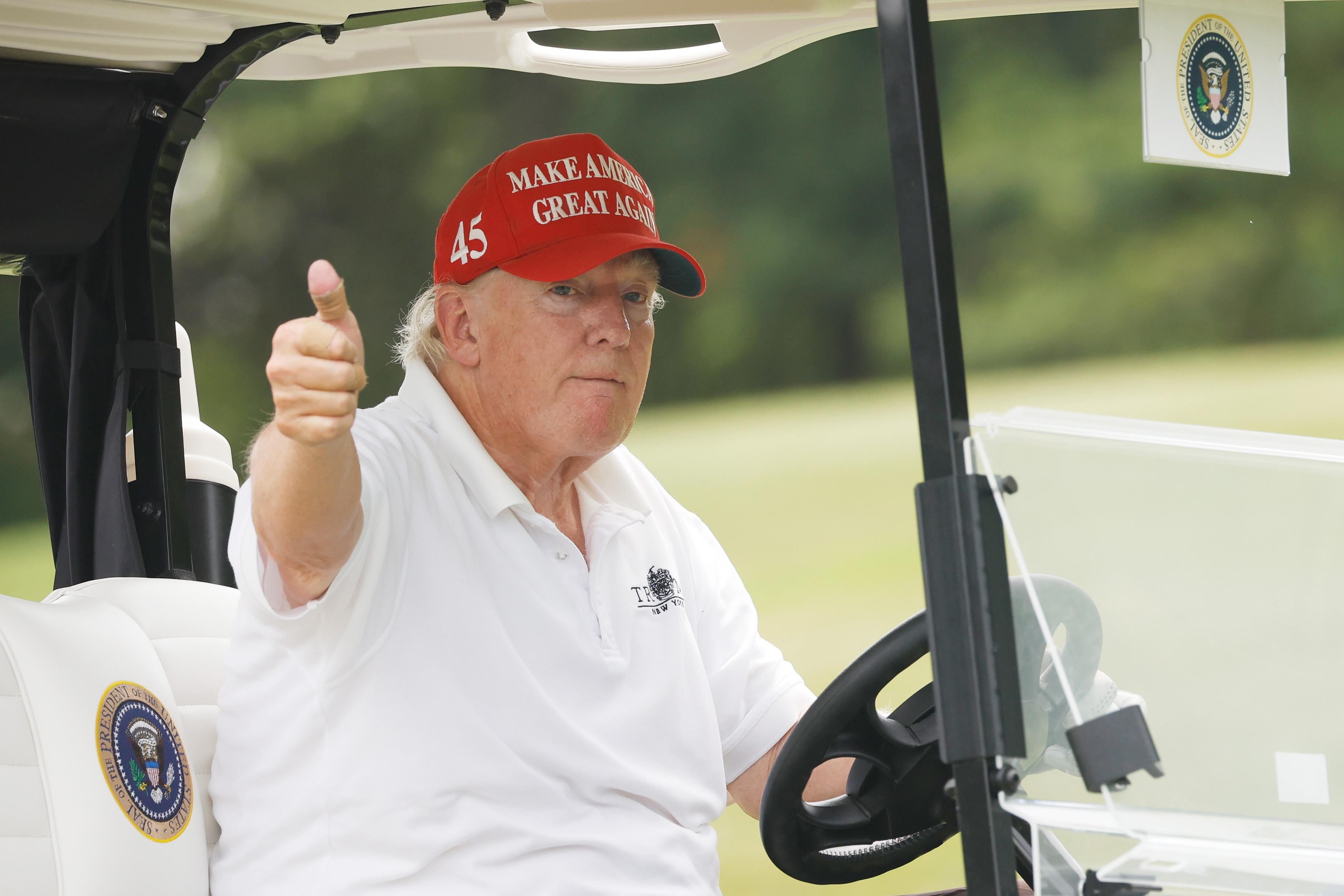 Trump looking pale and saggy in a golf cart.