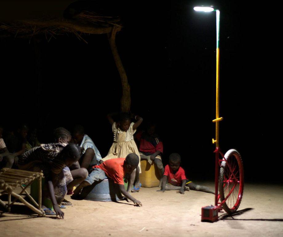Children gather under an LED light in Mali.