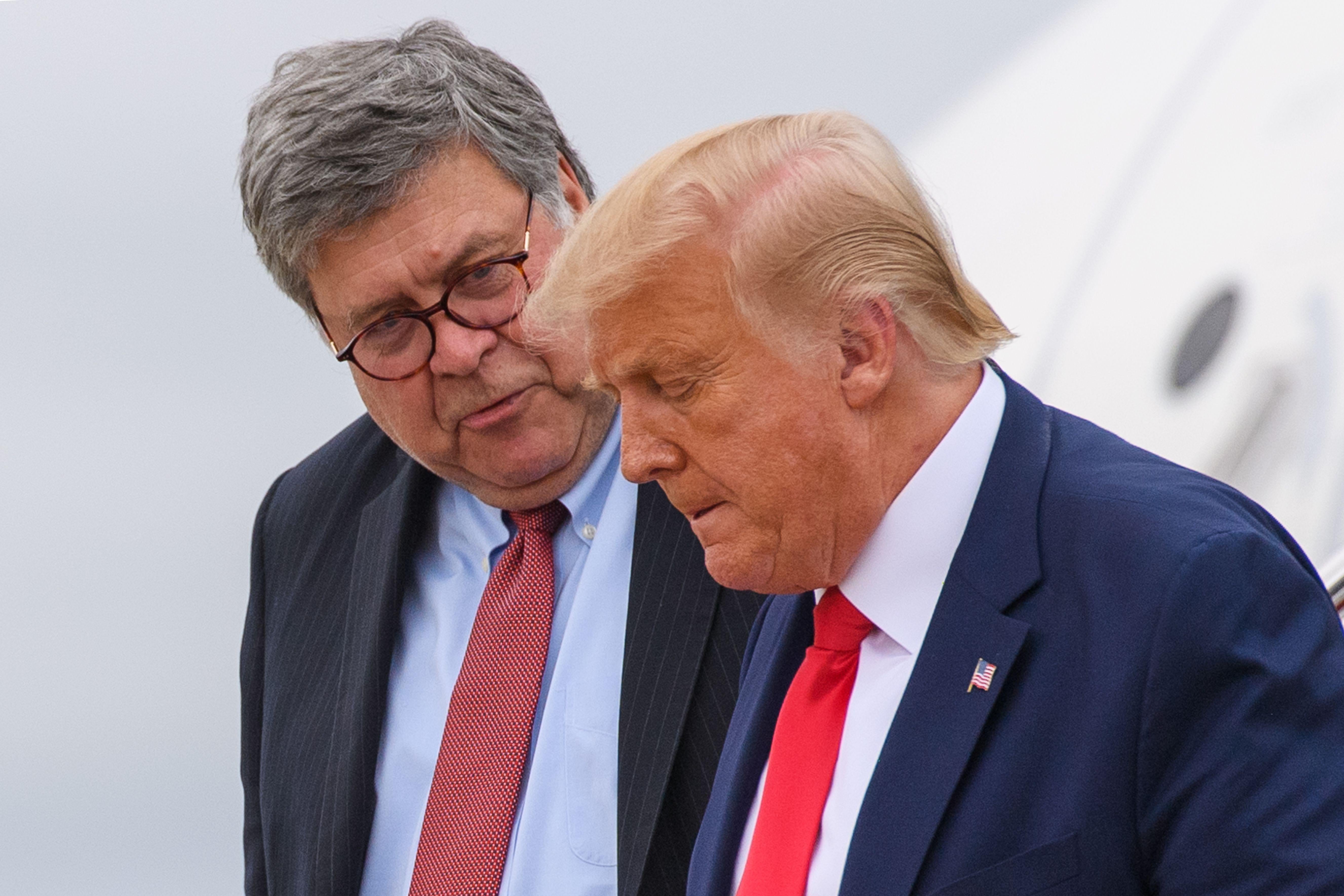 Barr speaks into Trump's ear as they walk down the steps of Air Force One.