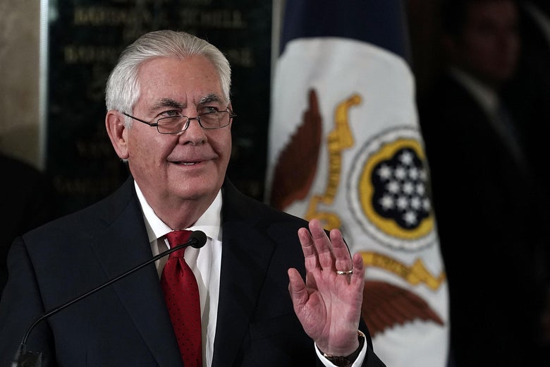 Tillerson waves during his farewell remarks. The flag of the State Department can be seen behind him.