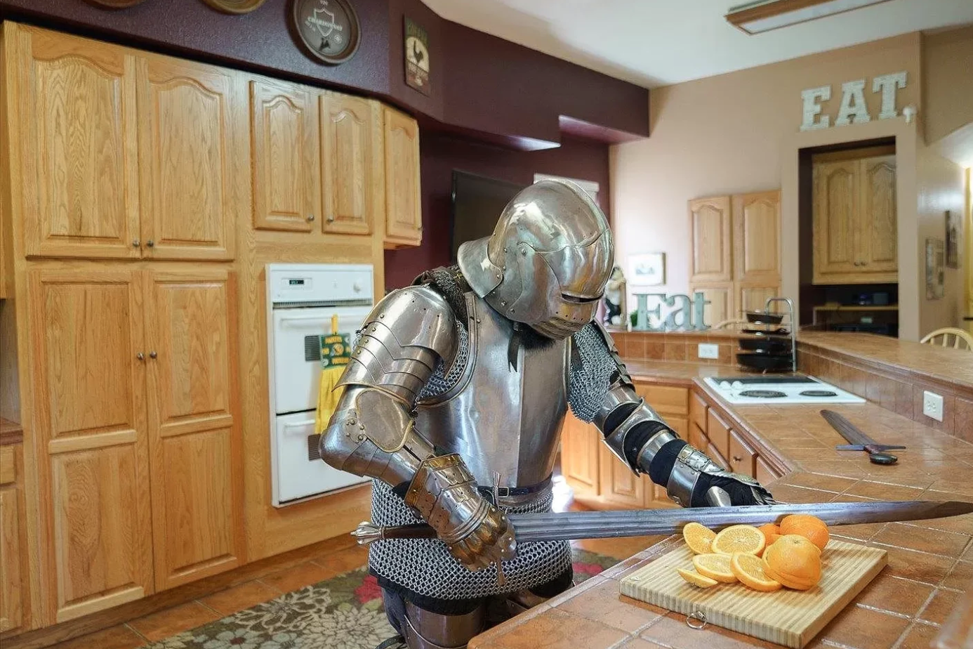 A knight slicing oranges in a large kitchen.