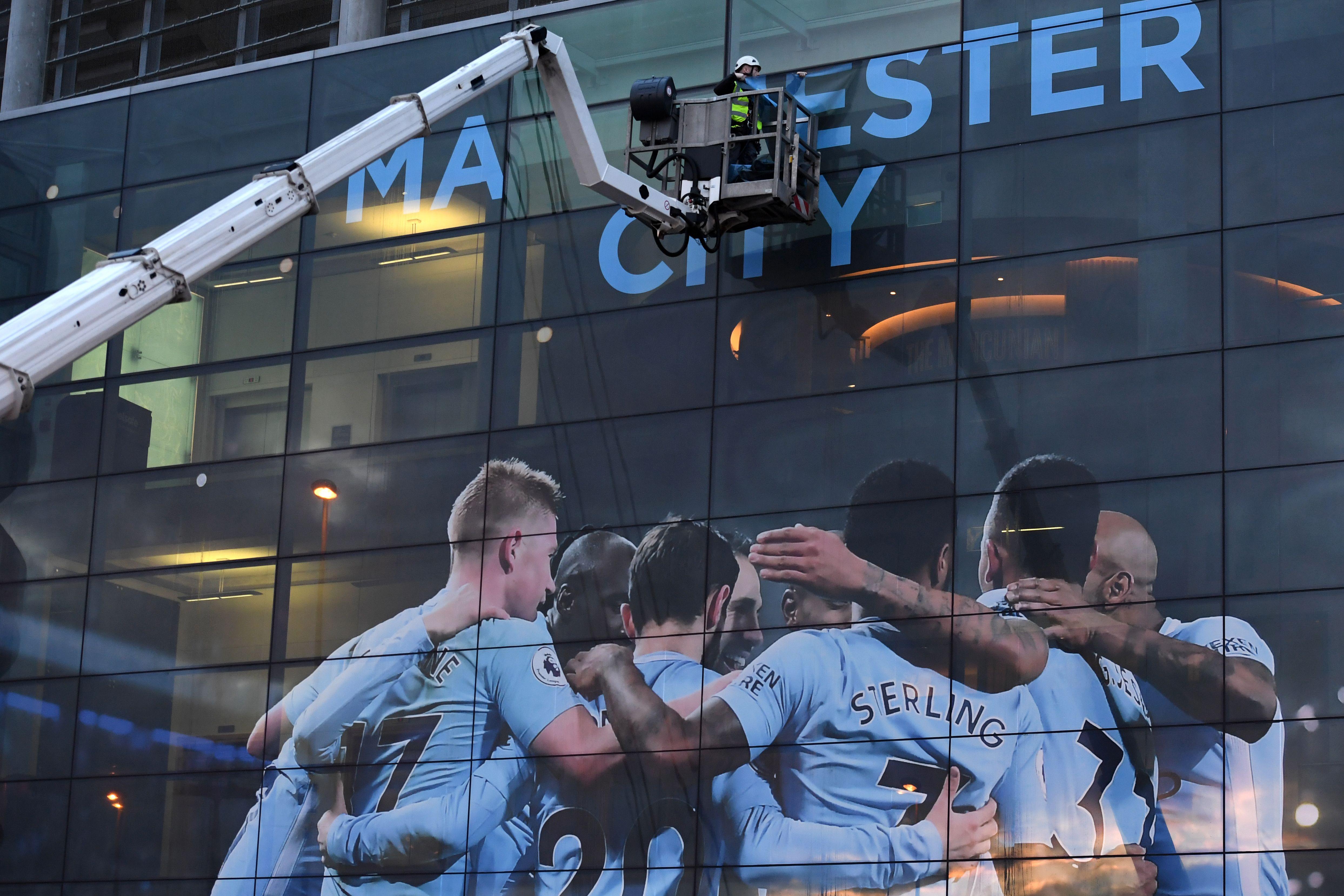 A workman begins to change the external panel designs on the Etihad Stadium in Manchester.