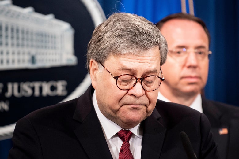 William Barr looks downward while standing at the lectern. Rod Rosenstein stands behind him.