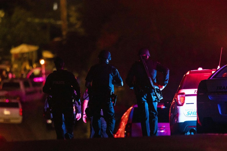 Police can be seen from behind at the scene of the shooting.