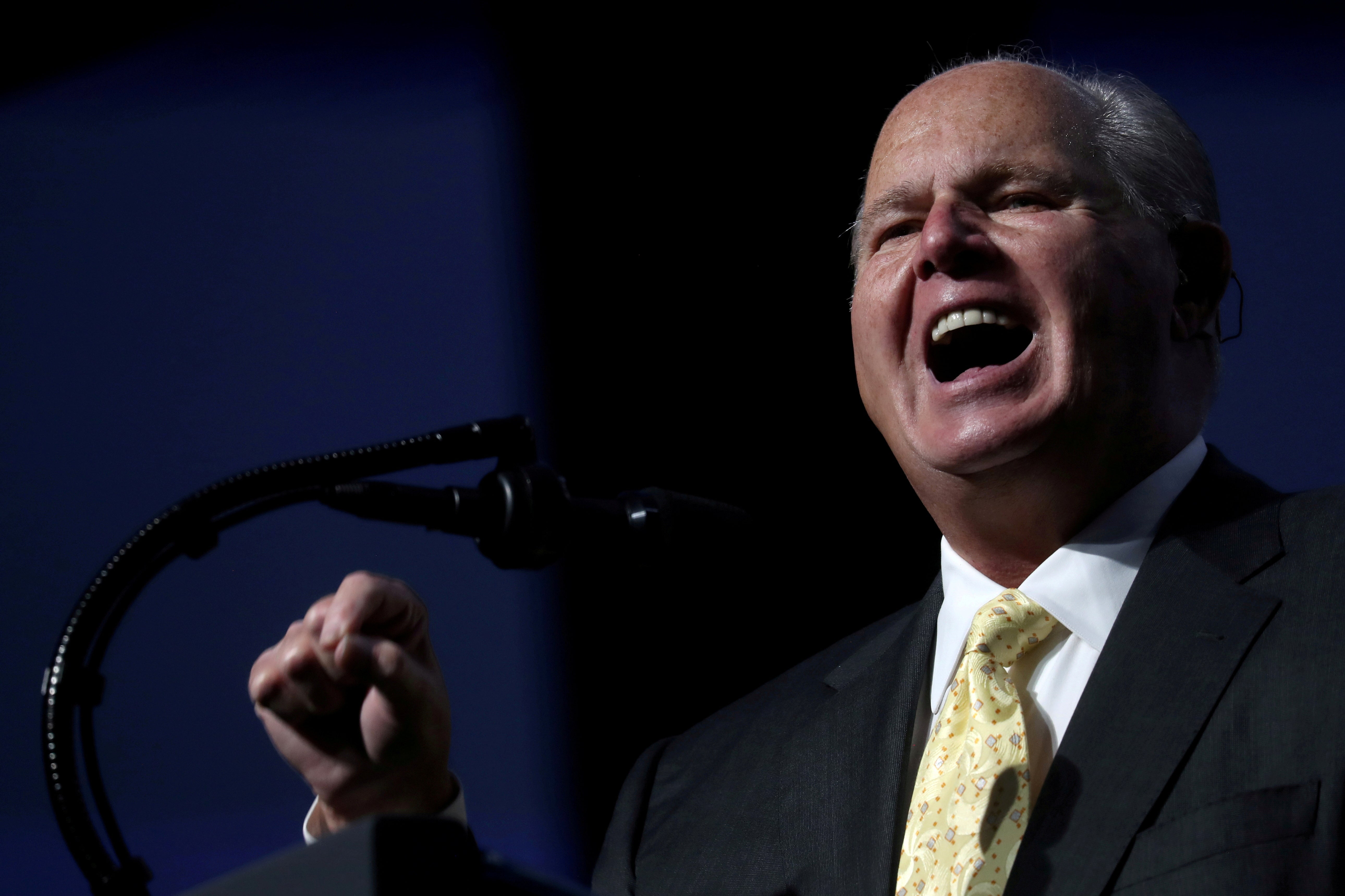 Rush Limbaugh points and speaks into a microphone.