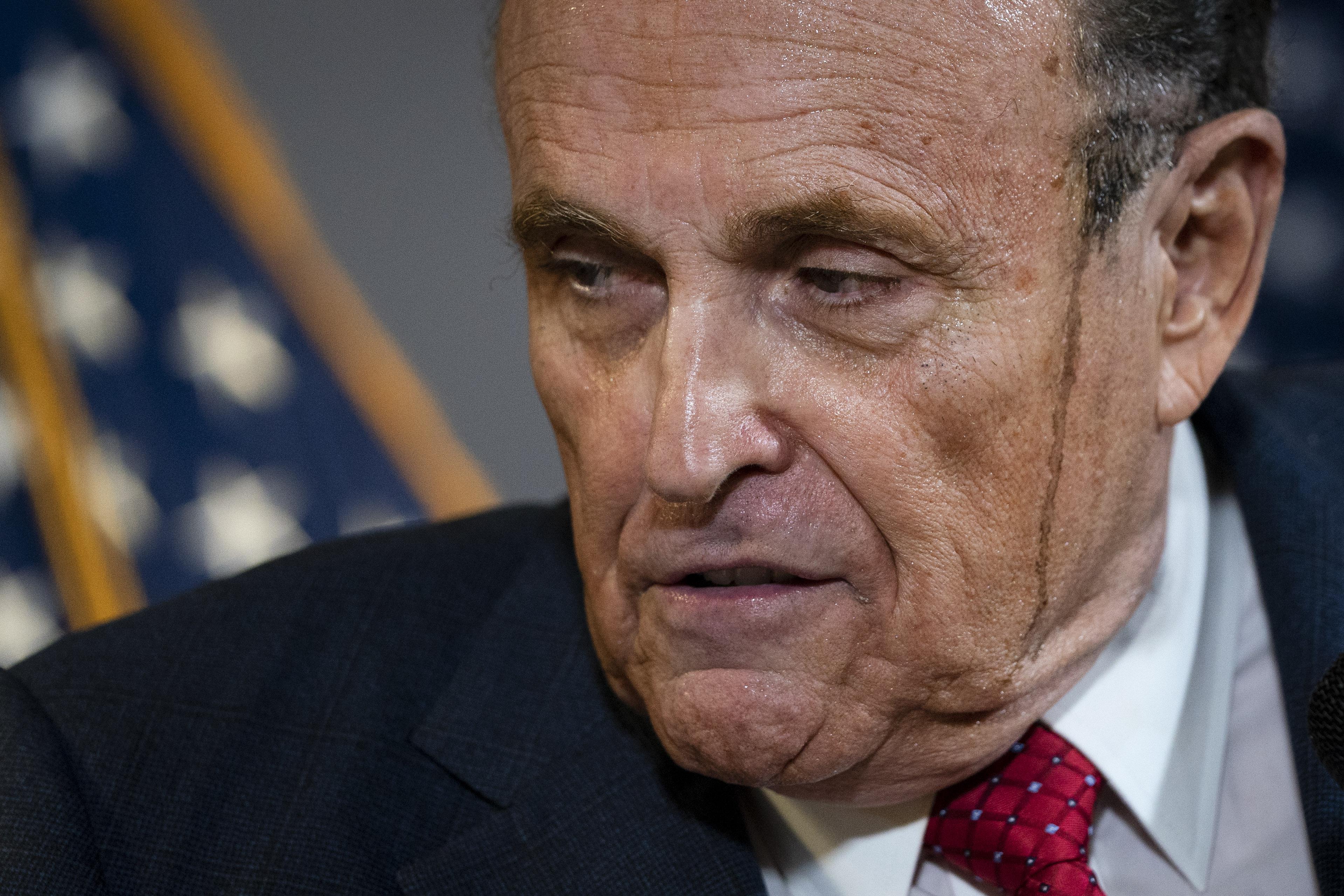 Close-up of Giuliani's face with a smear from apparent hair coloring running down the side of his face