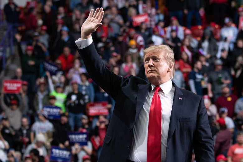 Trump waving in front of a crowd of his supporters.