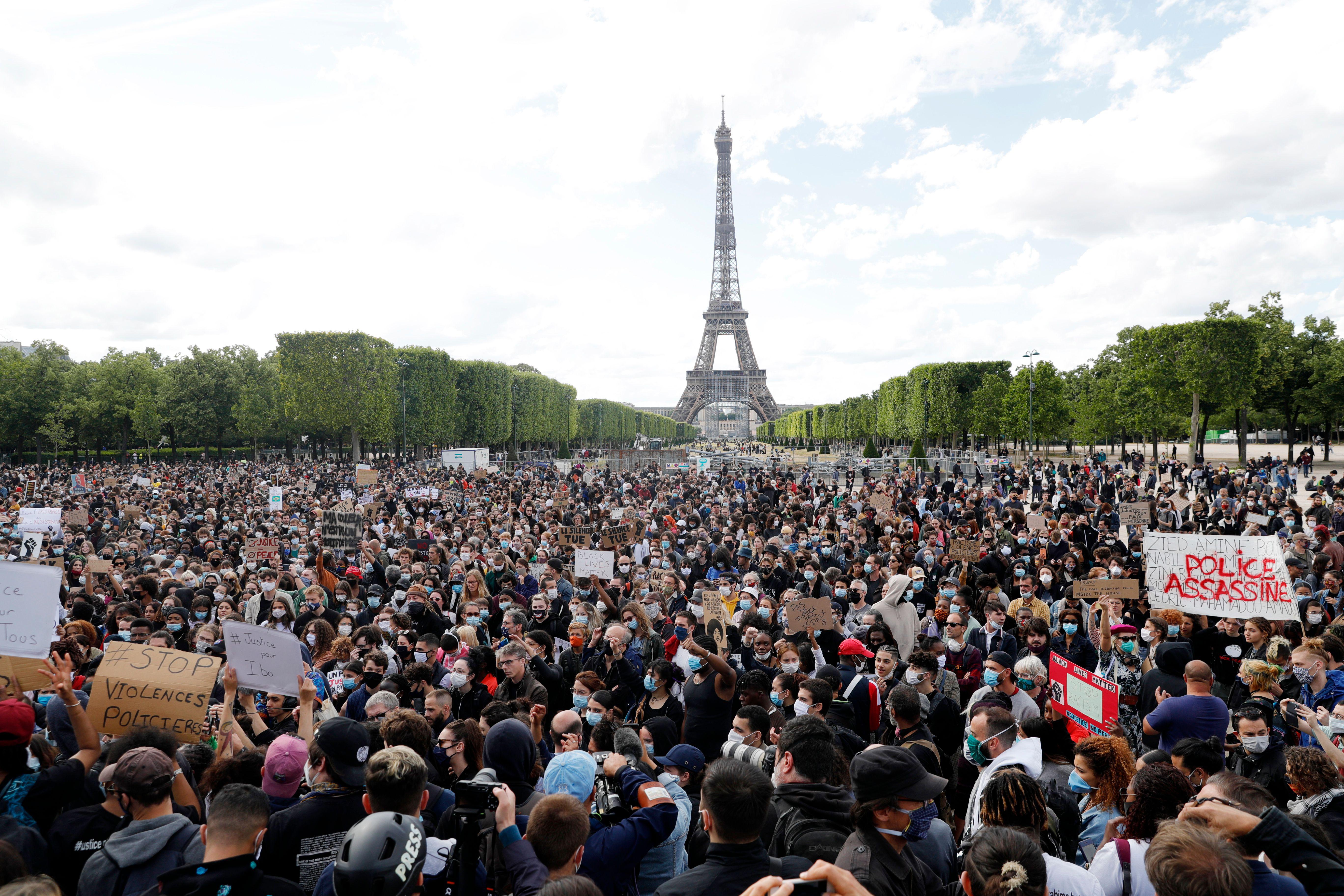 A huge crowd of protesters, with the Eiffel Tower in the background