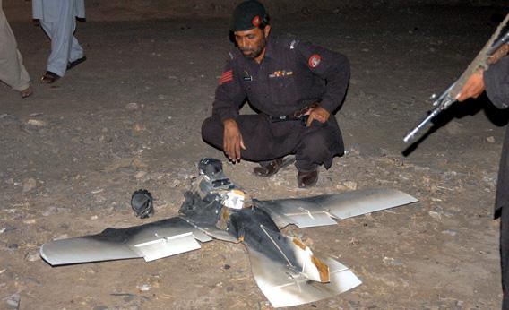 Pakistani security personnel examine a crashed American surveillance drone.