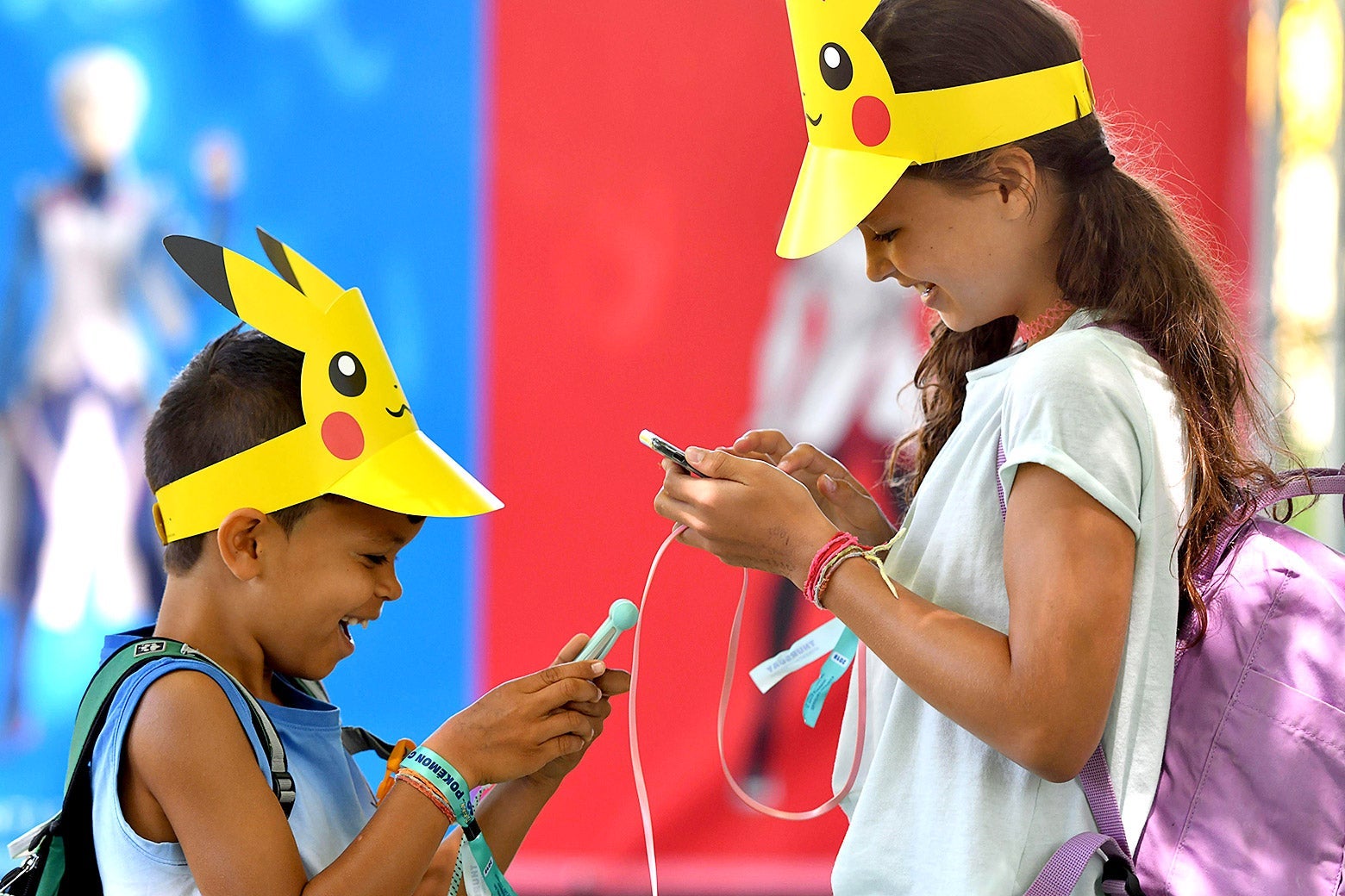 Switzerland's Leo, 9, and his sister Lea, 10, look at their phones during the Pokemon Go Festival on July 4, 2019 at the Westfalenpark in Dortmund, western Germany.