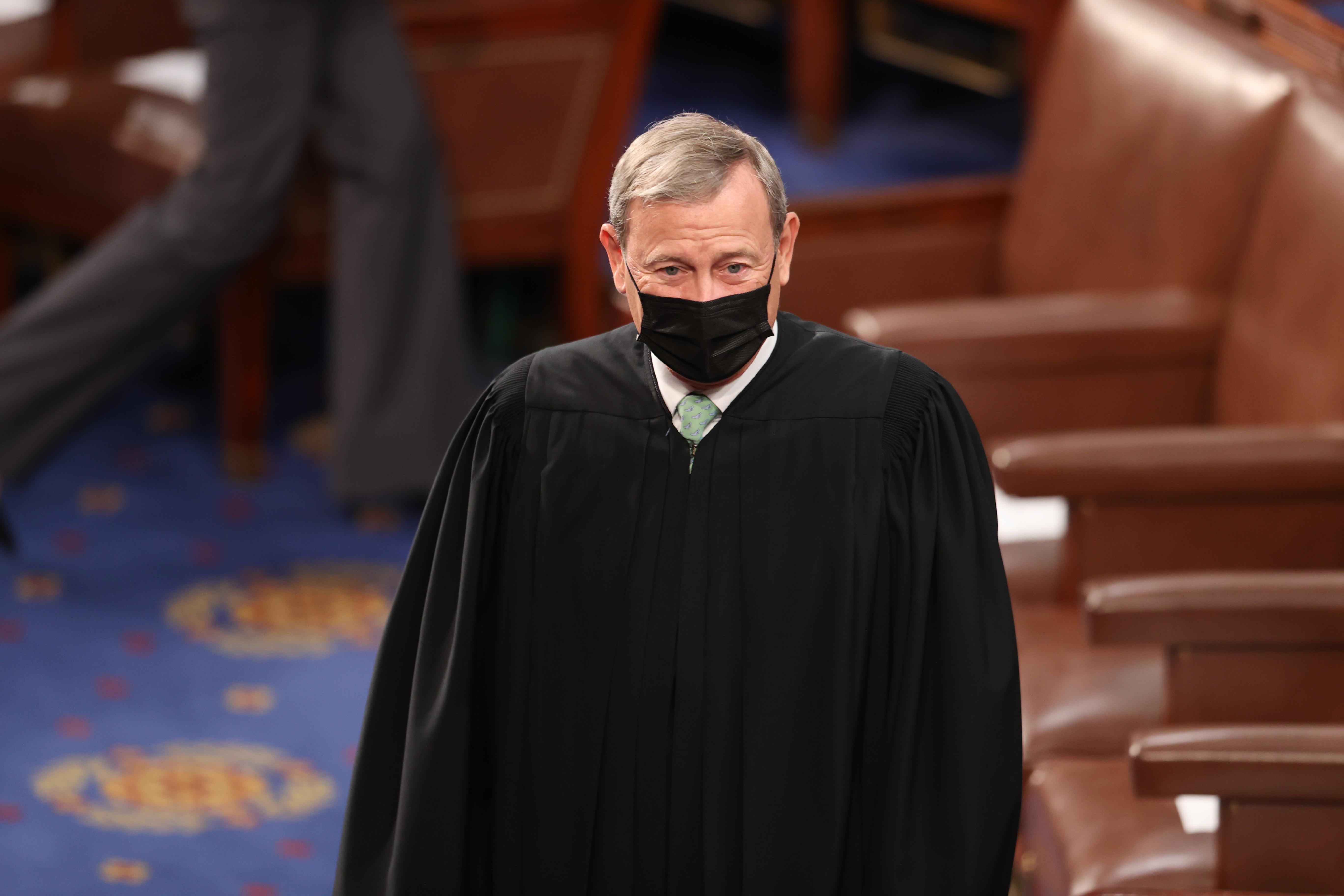 John Roberts in his robe and a simple black mask.