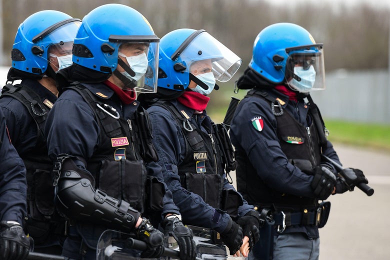 Police officers wearing protective face masks stand in a line.