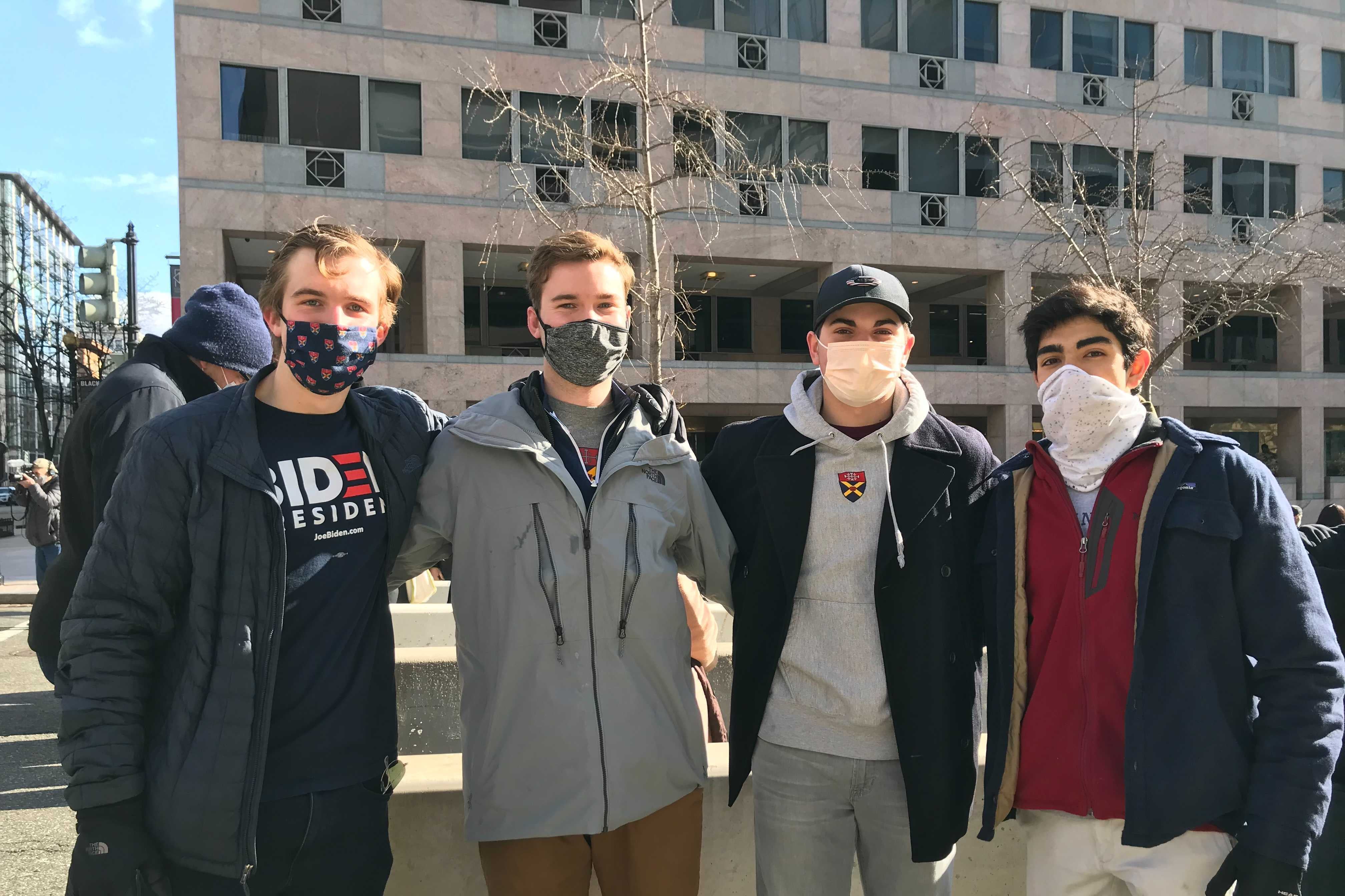 Four college-age men stand outside in downtown D.C.