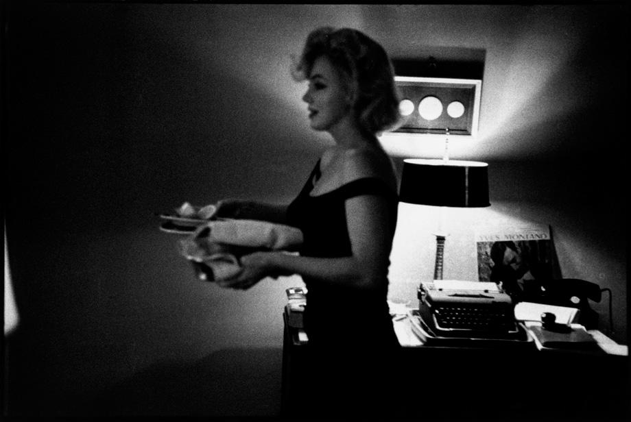 Hollywood, California. Marilyn Monroe cleaning up after dinner during the filming of “The Misfits”. 1960.