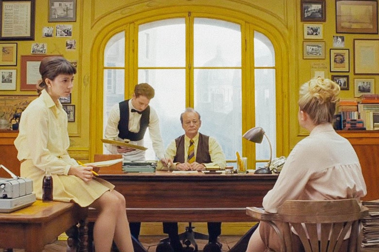 Bill Murray sits at a desk, symmetrically under a big window, in a bright-yellow room, with three other characters, bathed in warm light, positioned neatly around him.
