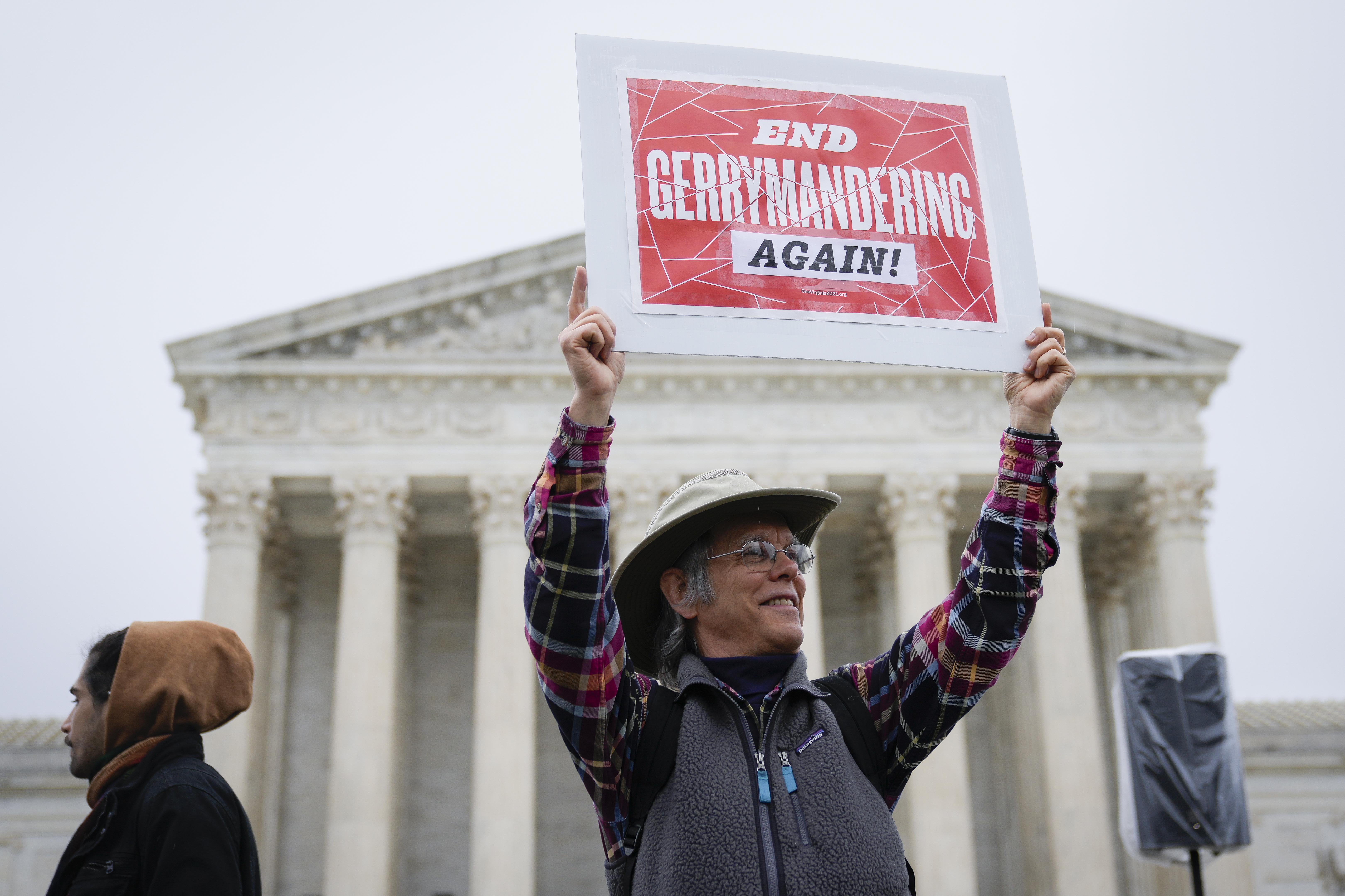 oting rights activists rally outside the U.S. Supreme Court during oral arguments in the Moore v. Harper case December 7, 2022 in Washington, DC. They're wearing a cowboy hat and carrying a sign that says "end Gerrymandering again!"