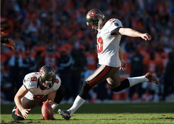 Punter Michael Koenen place-holds for kicker Connor Barth of the Tampa Bay Buccaneers during an extra point attempt against the Denver Broncos in December 2012.