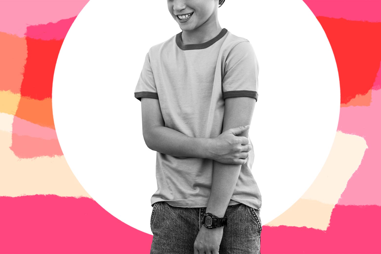A teenage boy smiling sheepishly, alone.