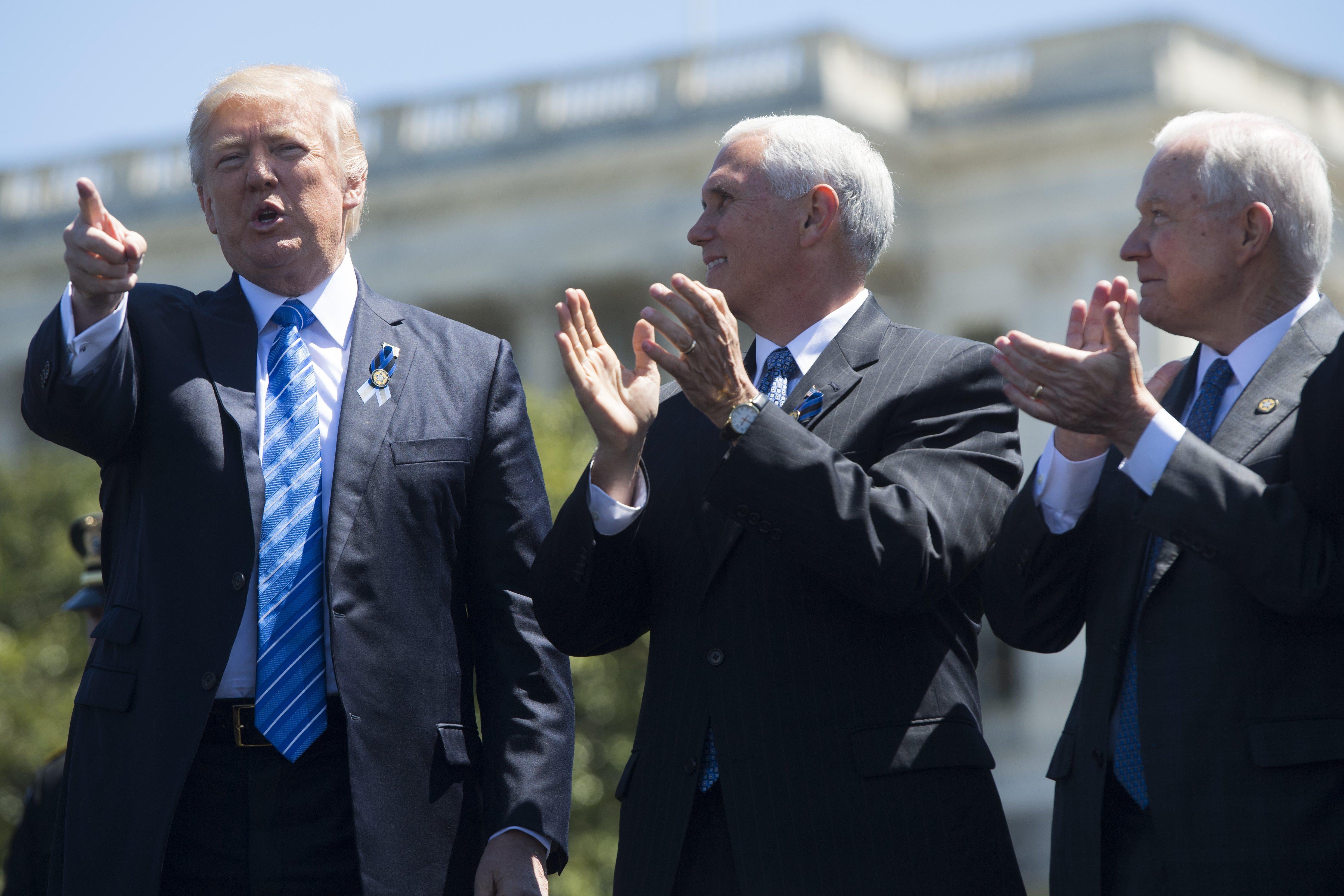 US President Donald Trump points alongside US Vice President Mike Pence (C) and Attorney General Jeff Sessions (R) during the 36th Annual National Peace Officers Memorial Service at the US Capitol in Washington, DC, May 15, 2017. / AFP PHOTO / SAUL LOEB        (Photo credit should read SAUL LOEB/AFP/Getty Images)
