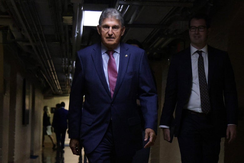 Manchin walking in a dark hallway