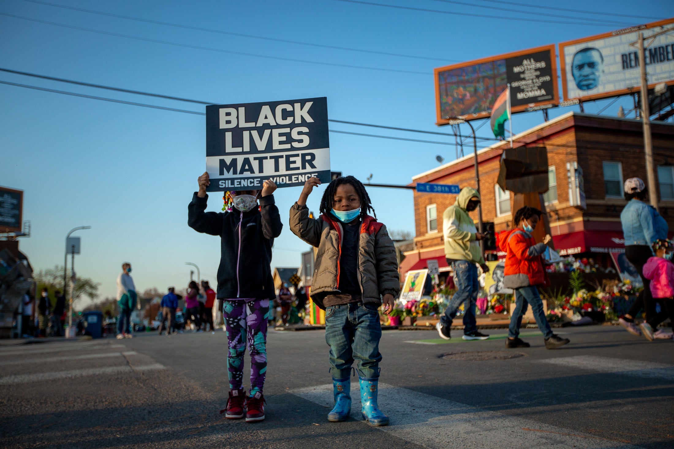 Two kids hold up a Black Lives Matter sign in George Floyd Square.