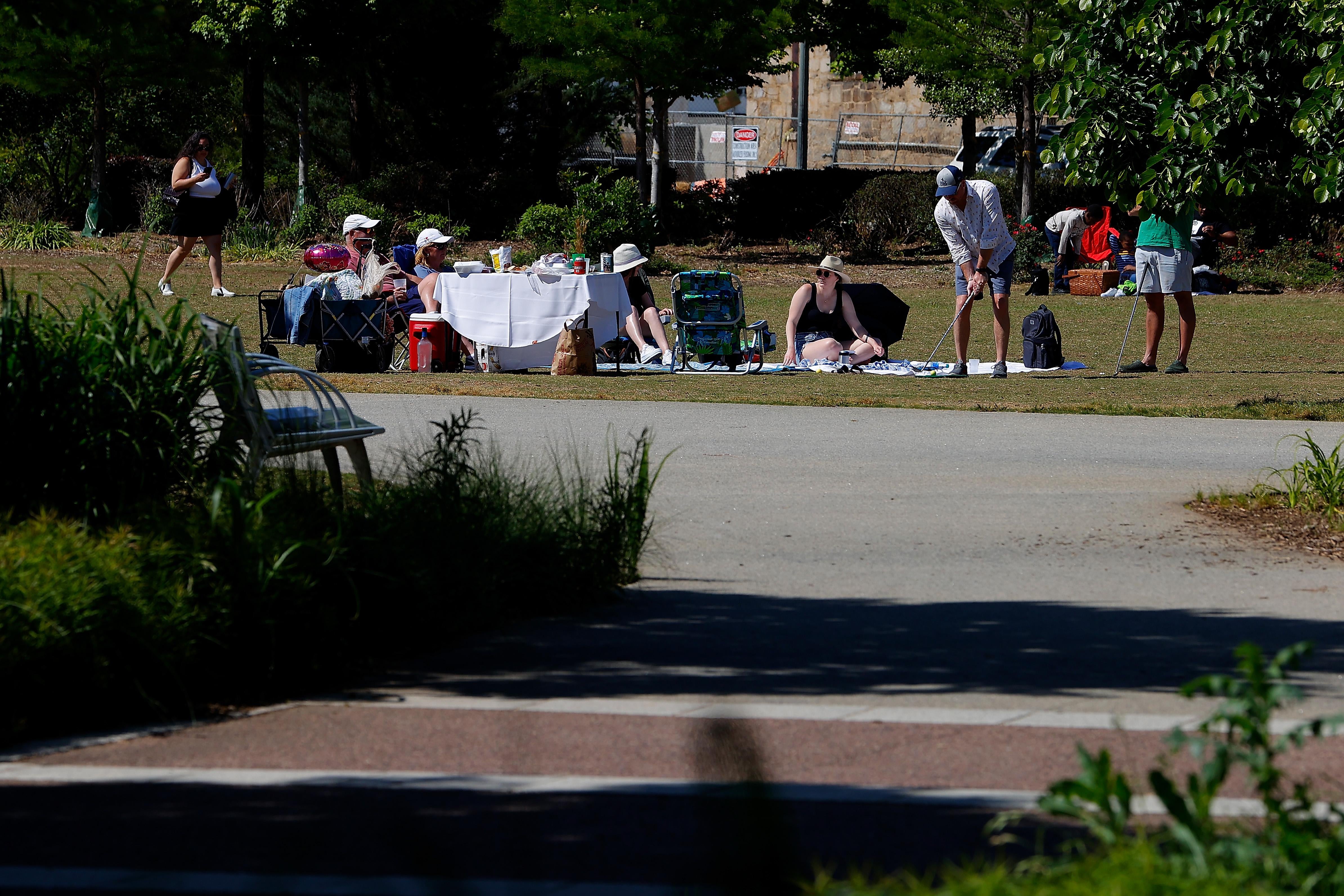 A group of people sit and have a picnic in the park