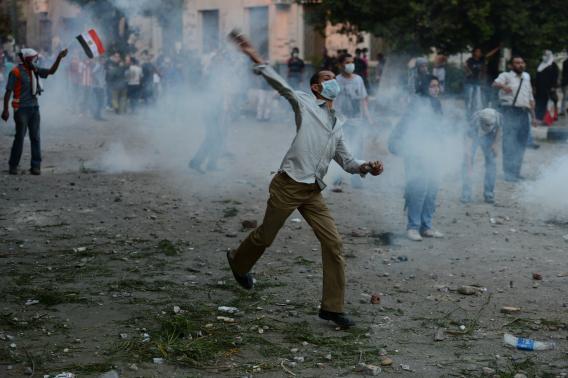 Egyptian protesters throw stones towards riot police during clashes near the US embassy in Cairo on Thursday.
