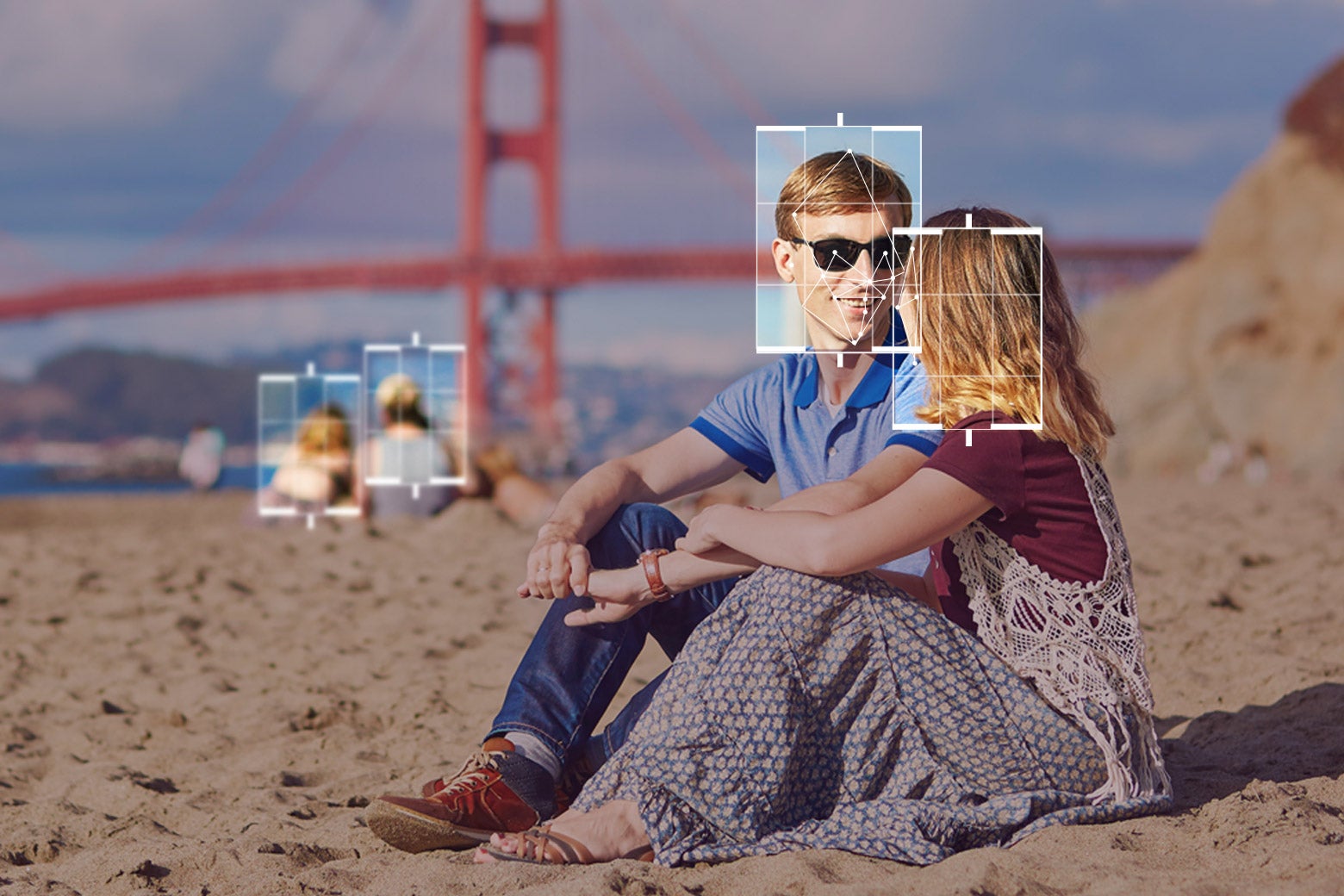 Photo illustration of two people sitting on a beach near the Golden Gate Bridge, but with facial recognition–esque highlights around their faces to note active surveillance.