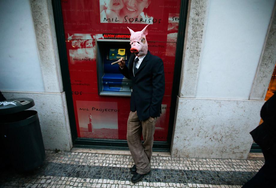 A demonstrator wearing a mask of a pig smokes during a march against government austerity policies in central Lisbon March 2, 2013. 
