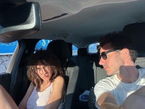 An annoyed-looking woman and a man sit in a car.