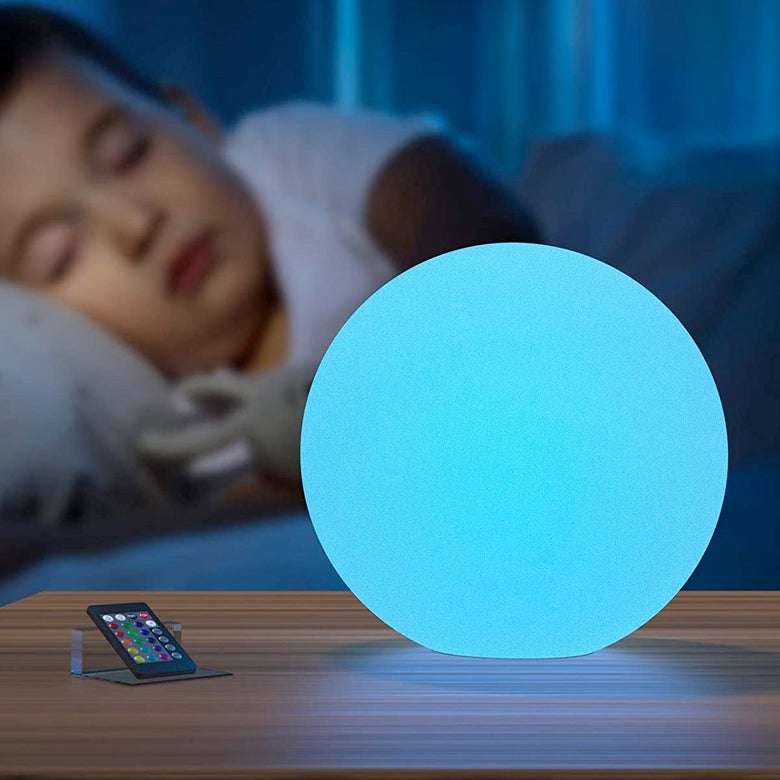 Glowing blue orb on a nightstand next to a child sleeping in bed