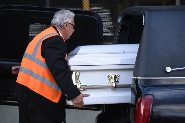 An employee of a funeral home loads into a hearse a coffin with the repatriated remains of seven-year-old Guatemalan migrant girl Jakelin Caal Maquin upon arrival in Guatemala City before being taken to her native San Antonio Seacortez village, in Raxruha 320 km north of the capital.
