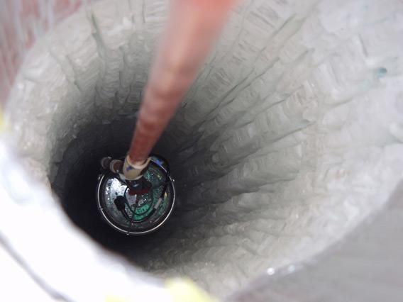 A detector being lowered into a hole drilled into the ice.