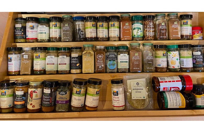 Jars of spices lined up along three shelves.