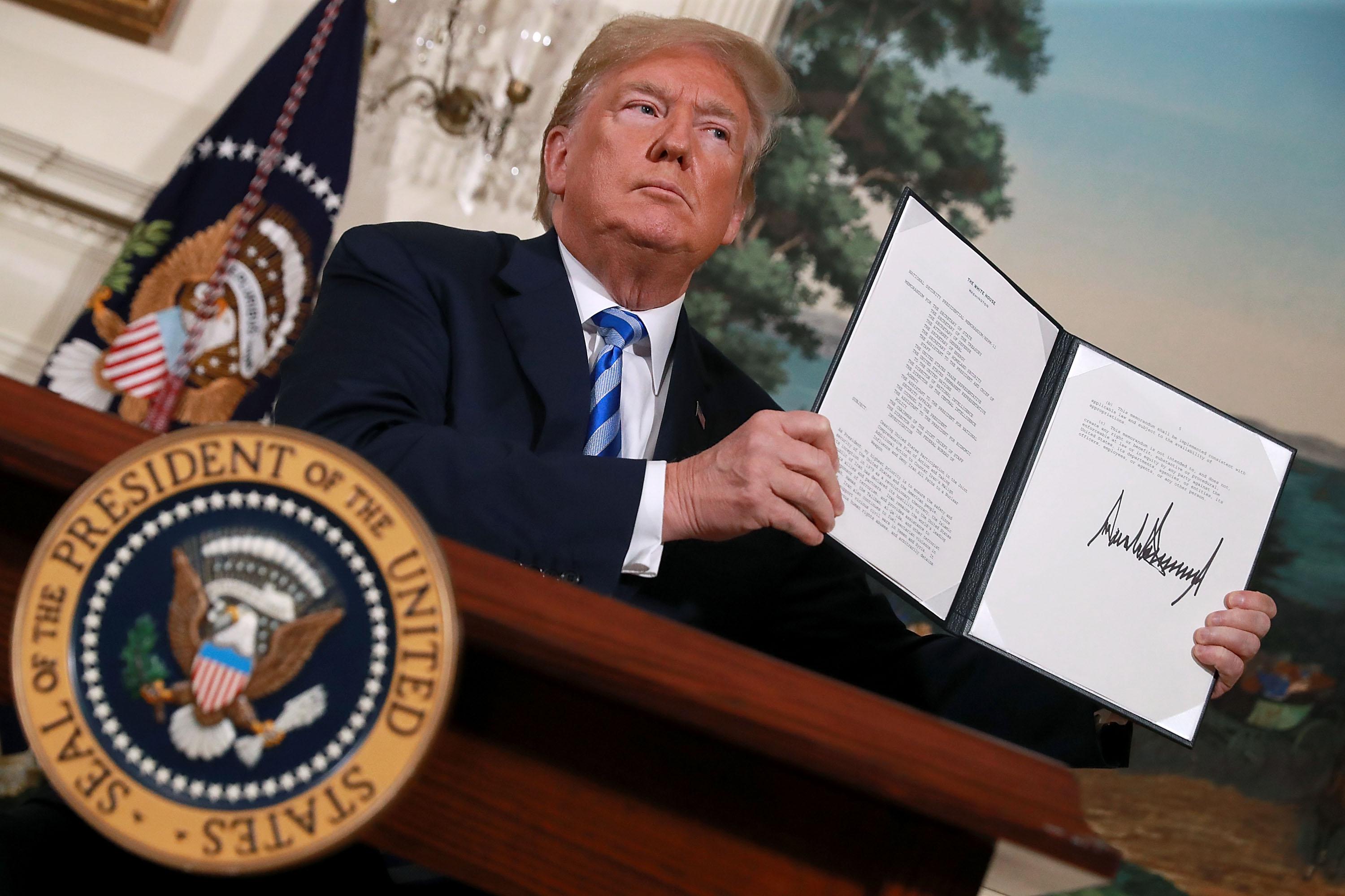 WASHINGTON, DC - MAY 08:  U.S. President Donald Trump holds up a memorandum that reinstates sanctions on Iran after he announced his decision to withdraw the United States from the 2015 Iran nuclear deal in the Diplomatic Room at the White House May 8, 2018 in Washington, DC. After two and a half years of negotiations, Iran agreed in 2015 to end its nuclear program in exchange for Western countries, including the United States, lifting decades of economic sanctions. Since then international inspectors have not found any violations of the terms by Iran.  (Photo by Chip Somodevilla/Getty Images)