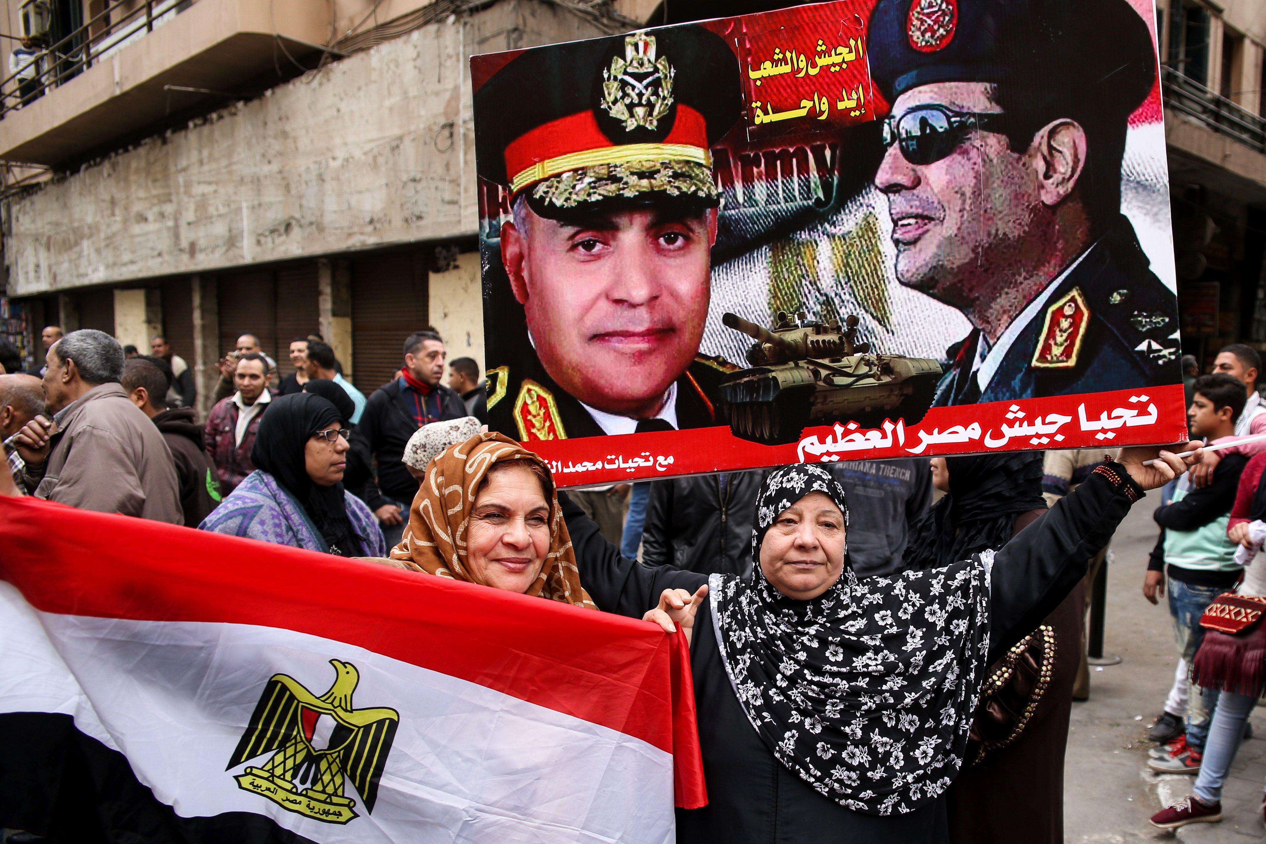 Egyptian women hold their national flag and a poster bearing portraits of President Abdel Fattah al-Sisi and Defense Minister Sedki Sobhi in Cairo's Tahrir Square on Jan. 25, 2017.