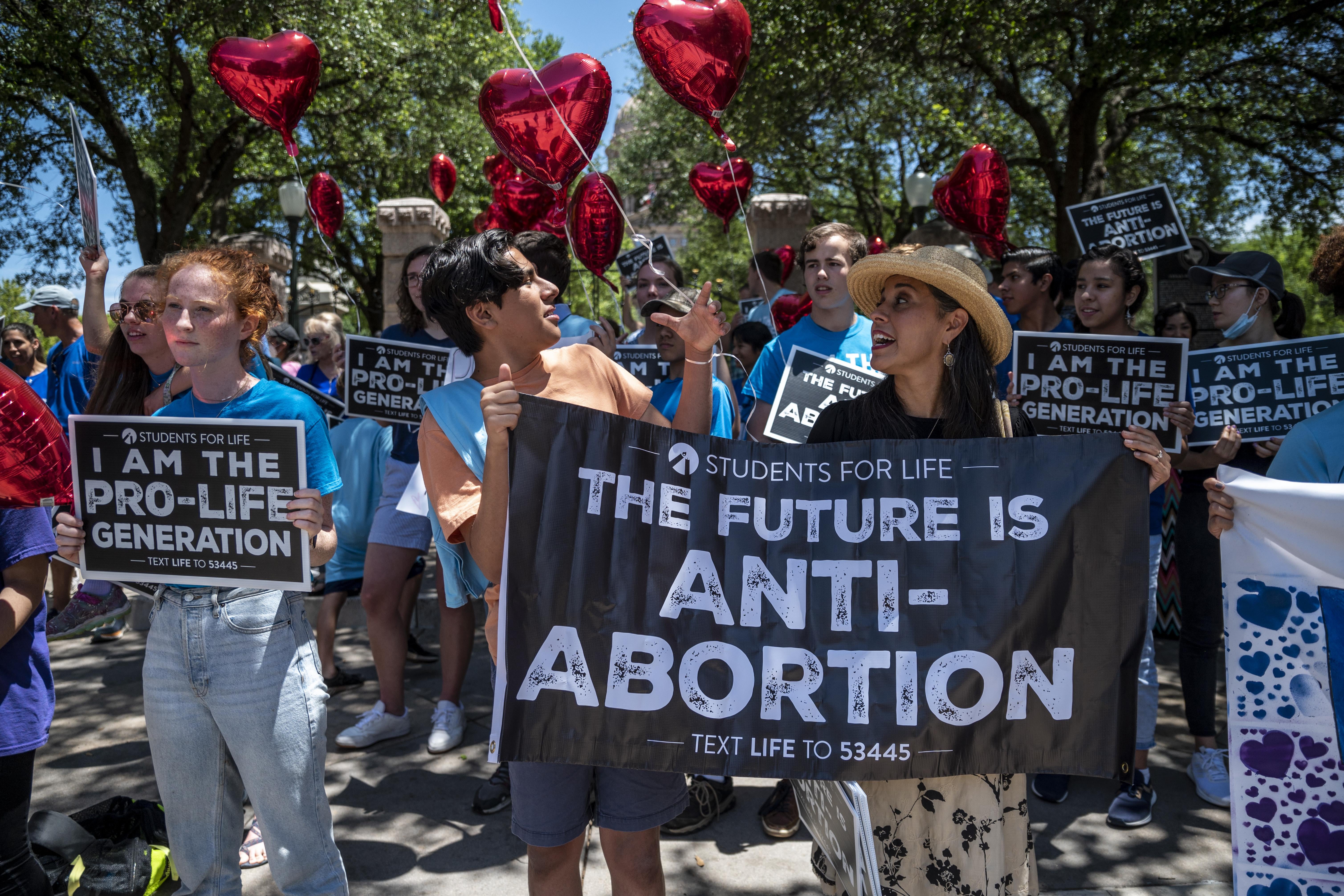 Protesters hold signs that read, "The future is anti-abortion."