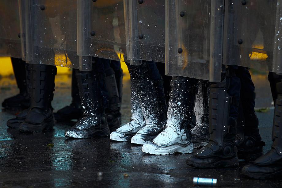 Riot police officers clash with opposition demonstrators during protests against President Nicolas Maduro's in Caracas.